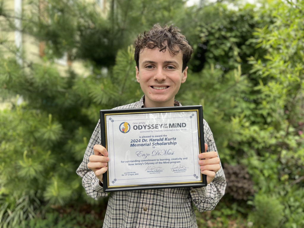 Student Enzo DiMasi holding his scholarshp award.