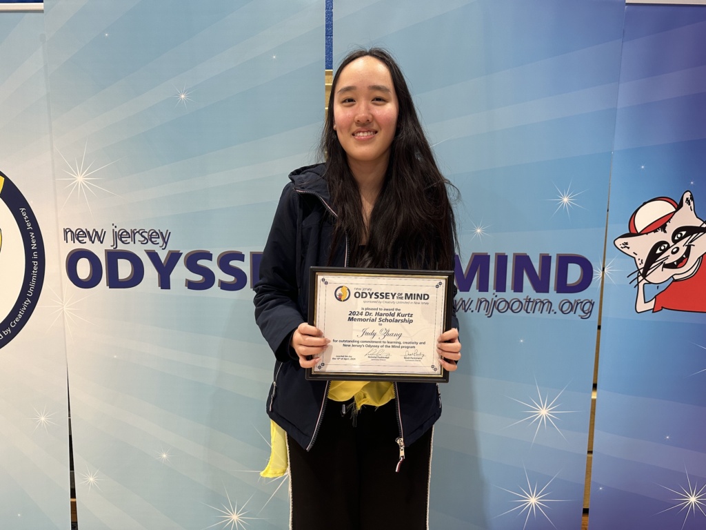 Student Judy Zhang holding her scholarship award.