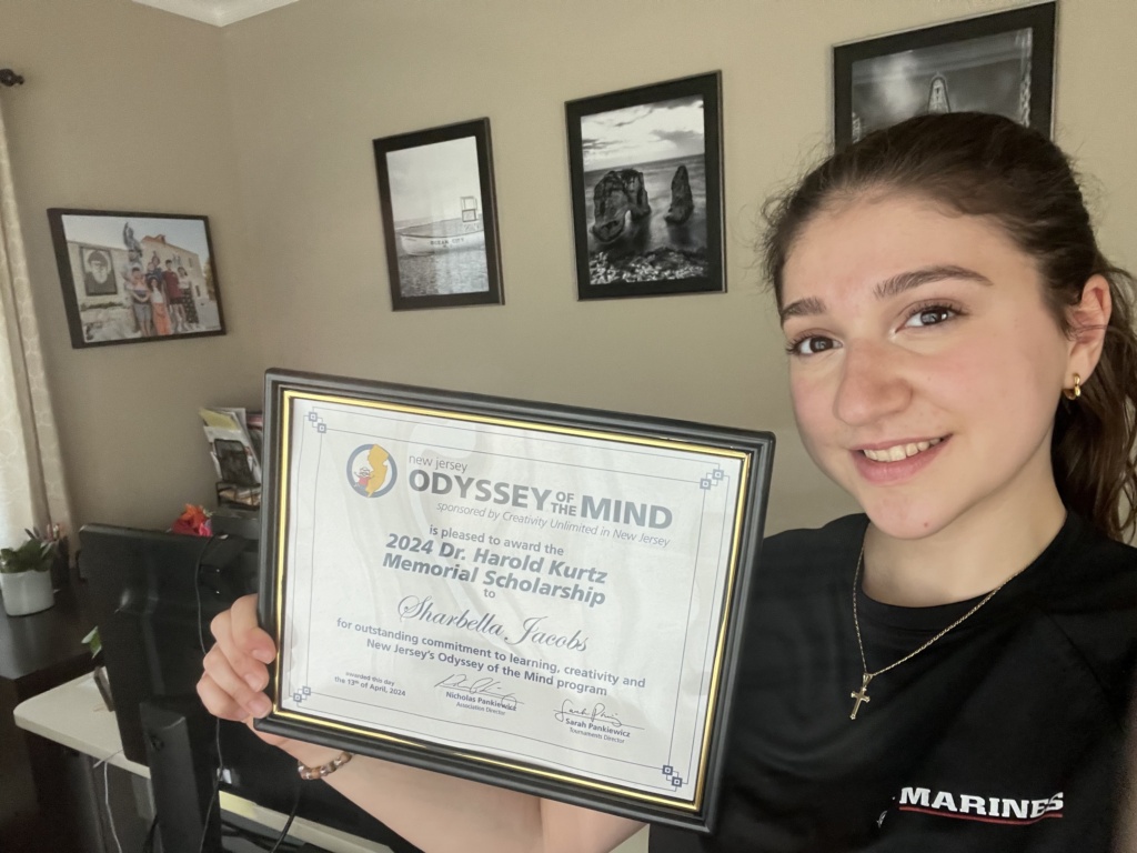 Student, Sharbella Jacobs, holding her scholarship award.