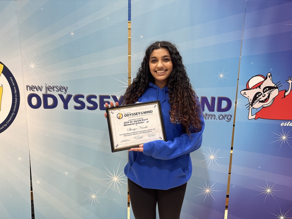 Student, Shreya Nanda, holding her scholarship award.