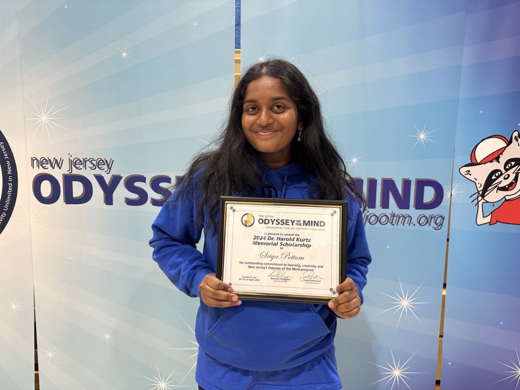 Young woman, Sryia Potturu, holding her scholarship award.